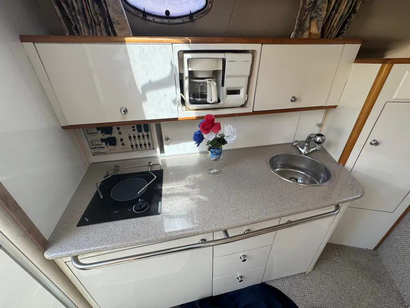 Slide: The Image of 1999 Chaparral 290 Signature Cruiser kitchen with stove, sink, and coffee maker. - 38