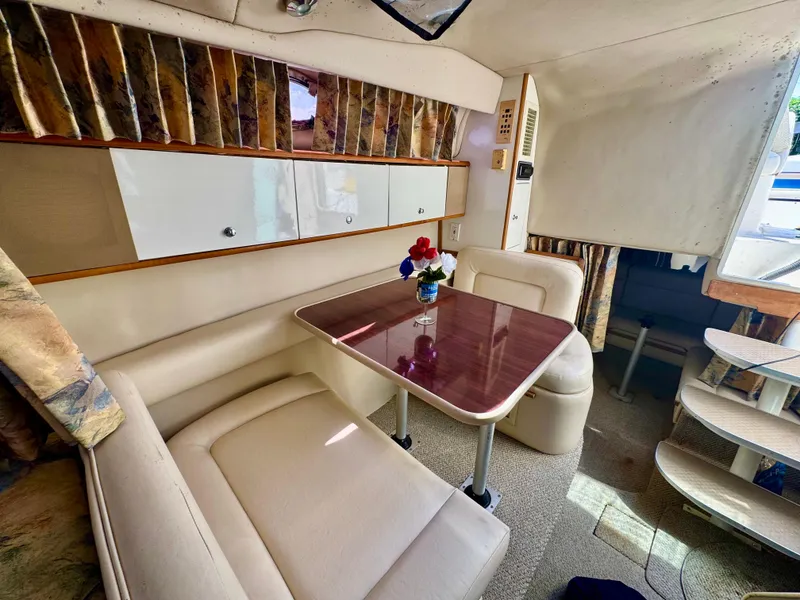 Slide: The Image of 1999 Chaparral 290 Signature Cruiser interior with dining area and table, featuring floral centerpiece. - 43