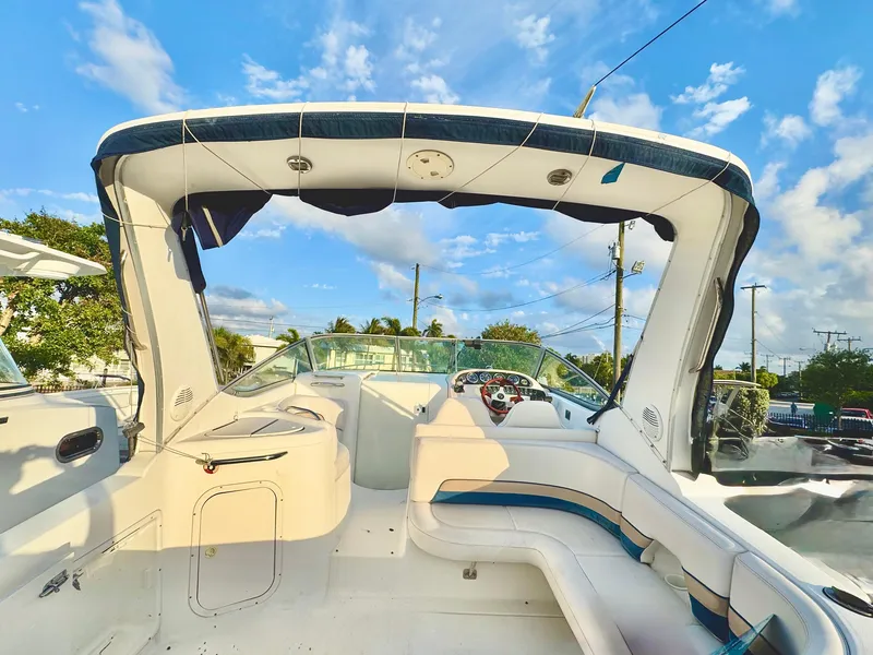 Slide: The Image of 1999 Chaparral 290 Signature Cruiser interior with seating and helm under a blue sky. - 48