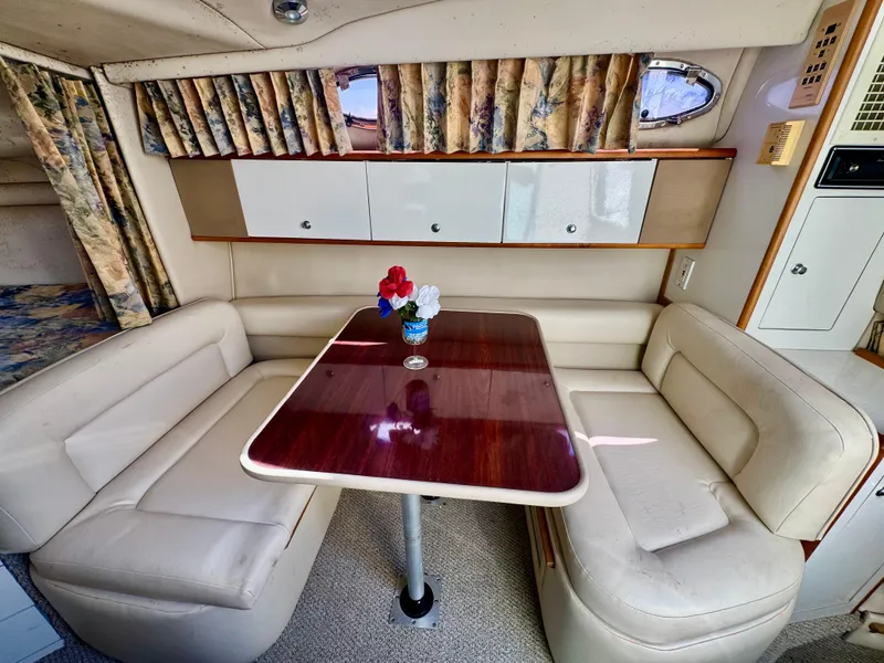 Slide: The Image of Interior of 1999 Chaparral 290 Signature Cruiser with cozy dining area and elegant wood table. - 5