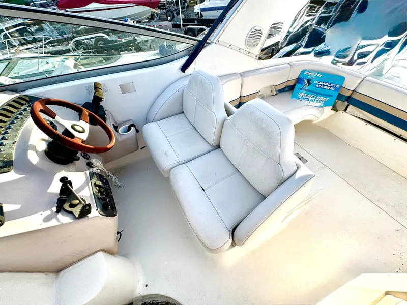 Slide: The Image of 1999 Chaparral 290 Signature Cruiser cockpit with white seating and wooden steering wheel. - 6
