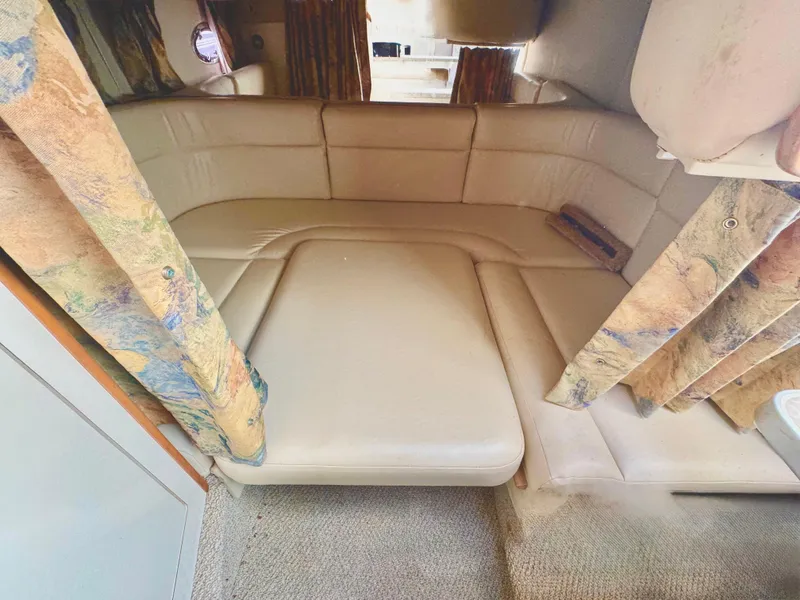 Slide: The Image of 1999 Chaparral 290 Signature Cruiser interior with beige seating and patterned curtains. - 8