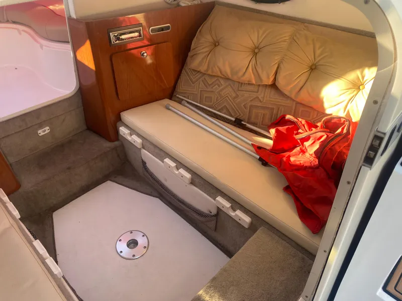 Slide: The Image of 2011 Ebbtide 2700 Cuddy Bow Rider interior with cushioned seating and storage. - 10