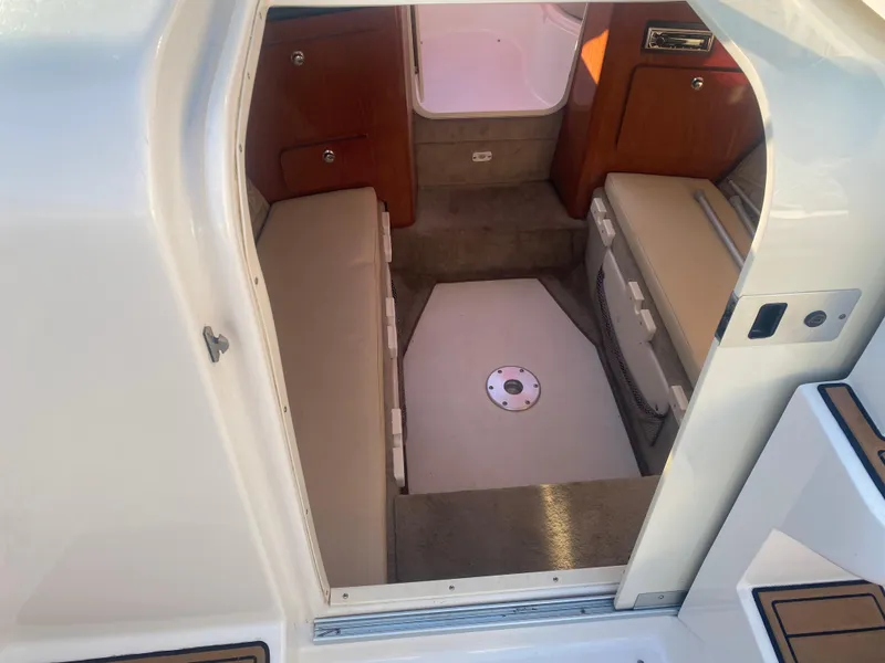 Slide: The Image of 2011 Ebbtide 2700 Cuddy Bow Rider cabin interior with seating and storage. - 12