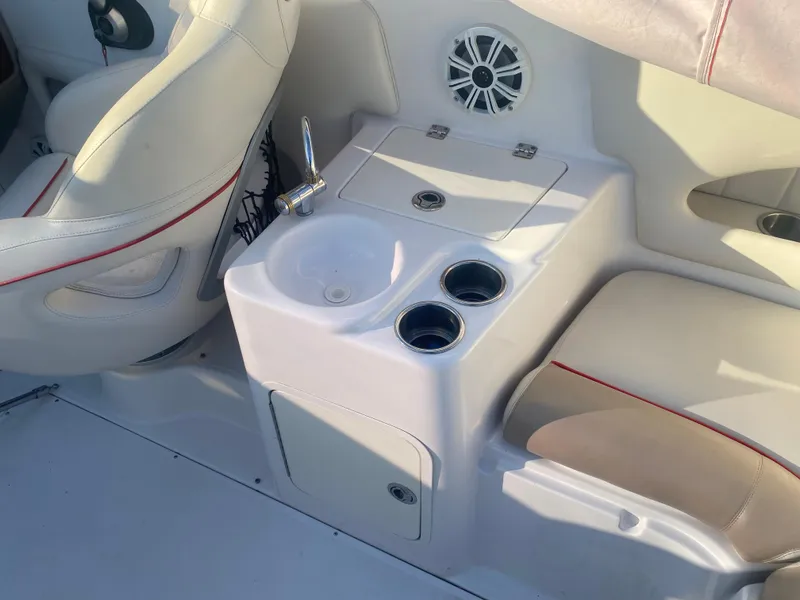 Slide: The Image of 2011 Ebbtide 2700 Cuddy Bow Rider interior with sink, cup holders, and seating. - 15