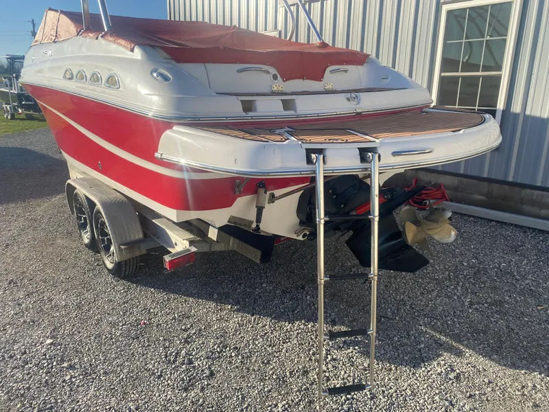 Slide: The Image of 2011 Ebbtide 2700 Cuddy Bow Rider boat with red and white exterior, parked on a trailer. - 18