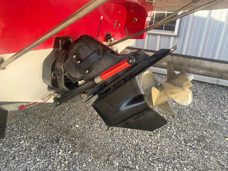 Slide: The Image of 2011 Ebbtide 2700 Cuddy Bow Rider boat propeller and outdrive on gravel surface. - 19