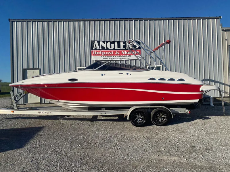 Slide: The Image of 2011 Ebbtide 2700 Cuddy Bow Rider boat on trailer, red and white design. - 3