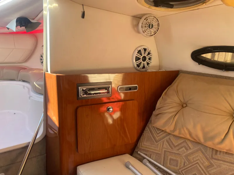 Slide: The Image of 2011 Ebbtide 2700 Cuddy Bow Rider interior with wood paneling and cushioned seating. - 6