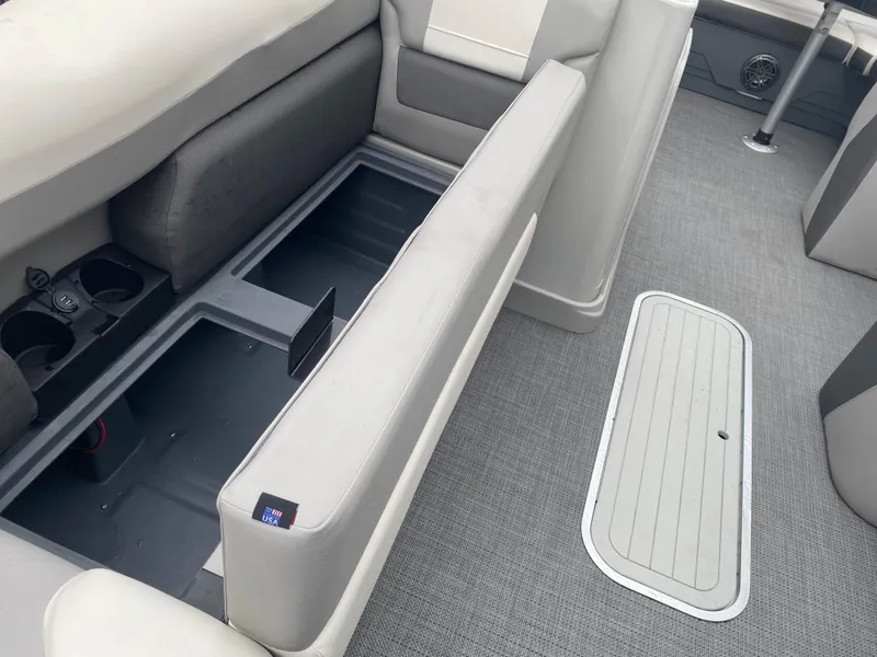 Slide: The Image of 2023 SunChaser Eclipse 8523 SBX boat interior with open storage compartment and cup holders. - 10