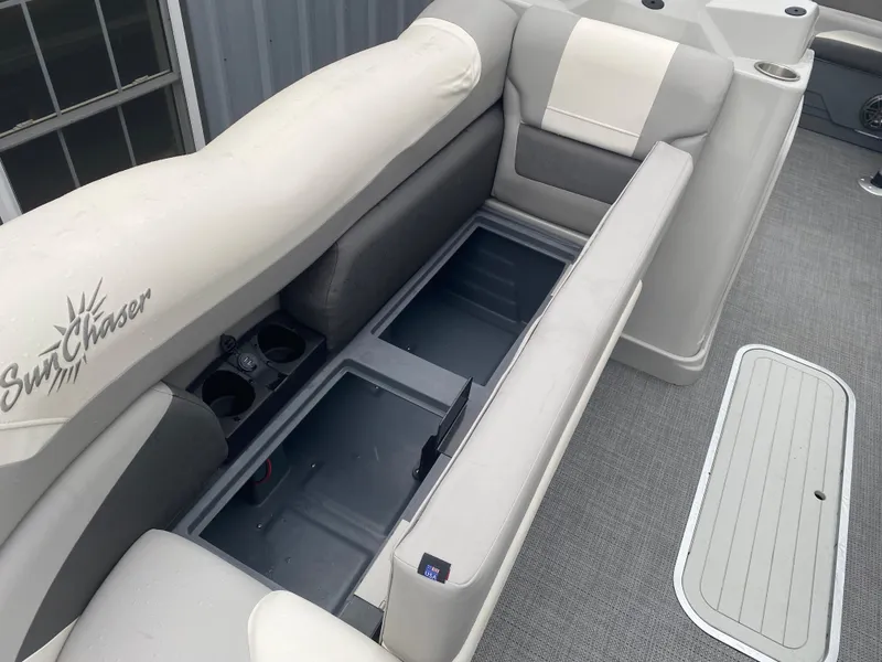 Slide: The Image of 2023 SunChaser Eclipse 8523 SBX boat interior with open storage compartment and cushioned seating. - 11