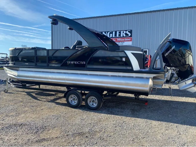 Slide: The Image of 2024 Trifecta 23 RFS 3.0 pontoon boat on trailer, parked outdoors. - 32