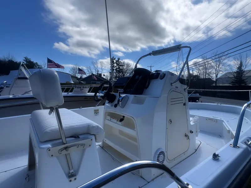 Slide: The Image of 2009 Boston Whaler 200 Dauntless boat with console and seating, under a partly cloudy sky. - 13