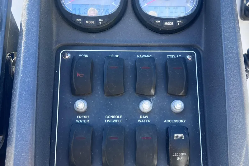Slide: The Image of Control panel of a 2009 Boston Whaler 200 Dauntless boat with switches and gauges. - 15