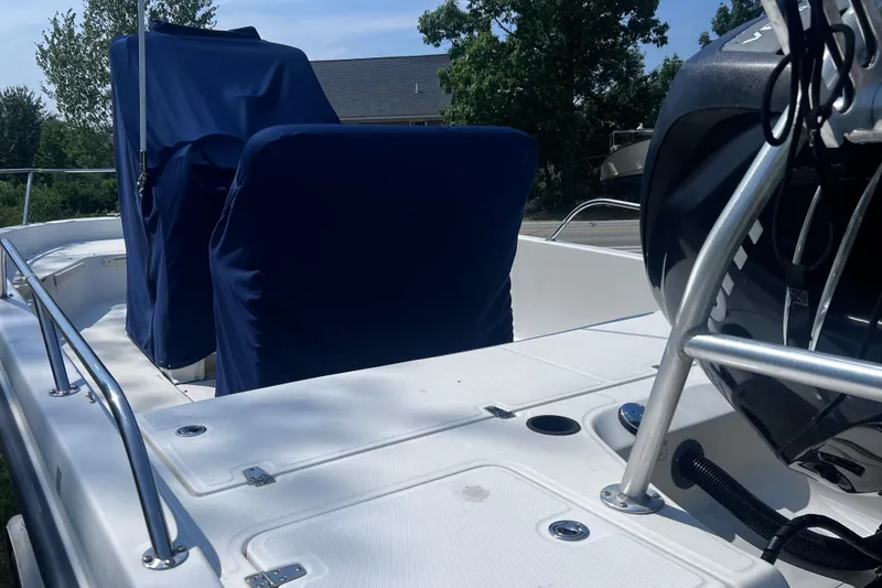 Slide: The Image of 2009 Boston Whaler 200 Dauntless boat interior with blue seat covers and motor. - 22