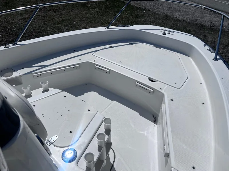 The Image of 2009 Boston Whaler 200 Dauntless boat deck with rod holders and storage compartments. - 6