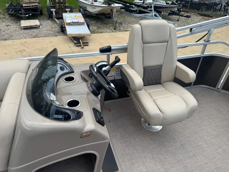 Slide: The Image of 2023 Sun Tracker Party Barge 20 DLX helm with beige captain's chair and steering console. - 5