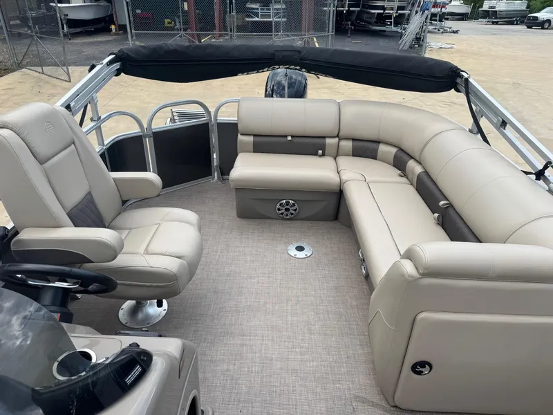 Slide: The Image of 2023 Sun Tracker Party Barge 20 DLX interior with beige seating and spacious layout. - 6