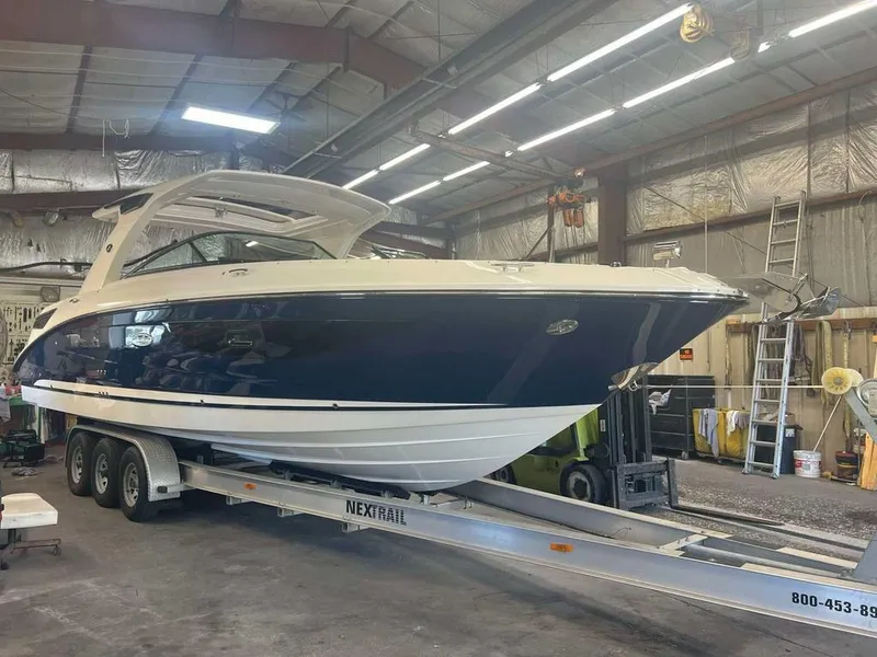Slide: The Image of 2023 Sea Ray SLX 350 boat on trailer in a warehouse setting. - 0