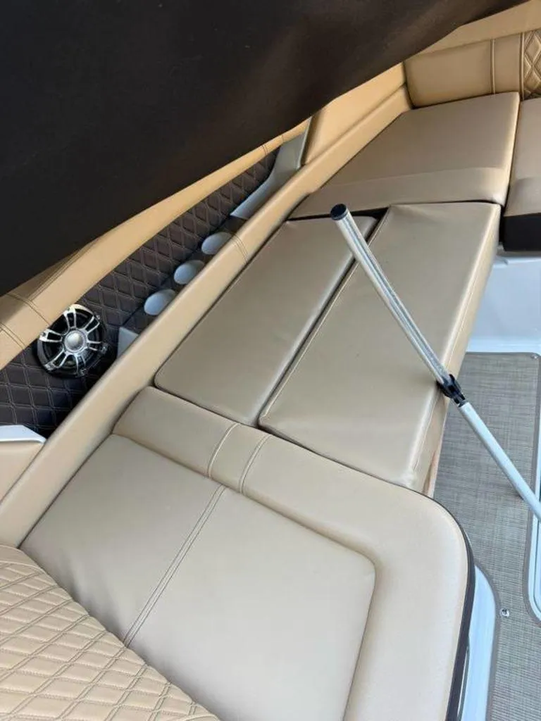 Slide: The Image of 2023 Sea Ray SLX 350 interior with beige leather seating and speaker system. - 2