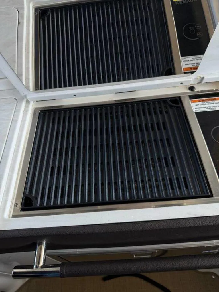 Slide: The Image of Outdoor grill on 2023 Sea Ray SLX 350 boat, featuring sleek black grates. - 6