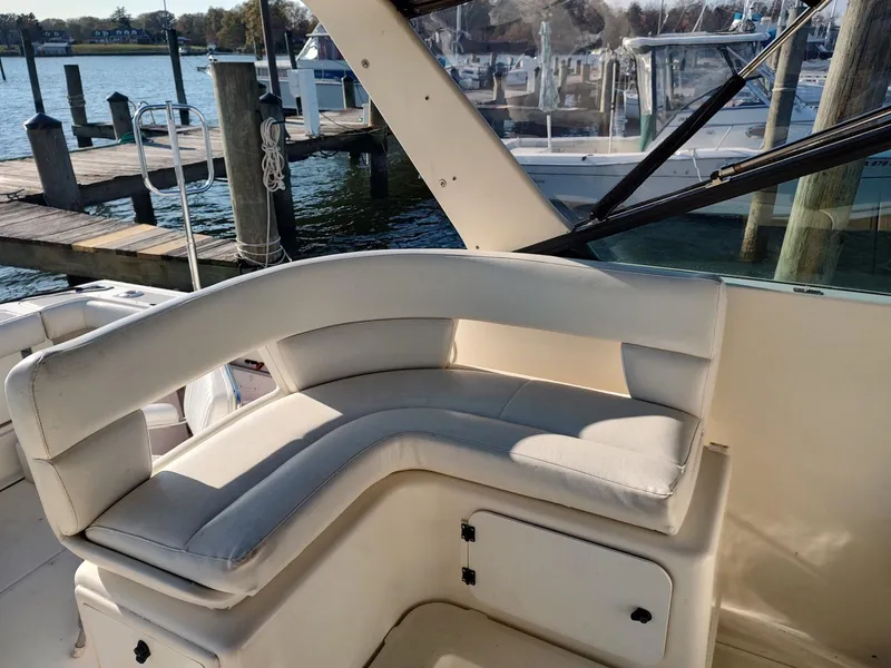Slide: The Image of 1994 Tiara Yachts 3100 Open interior with white seating, docked at marina. - 11