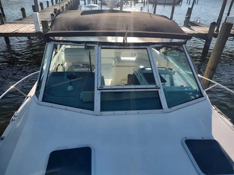 Slide: The Image of 1994 Tiara Yachts 3100 Open boat docked, featuring a sleek design and spacious cockpit. - 13