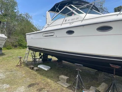 Slide: The Image of 1994 Tiara Yachts 3100 Open on stands, undergoing maintenance in a grassy area. - 20