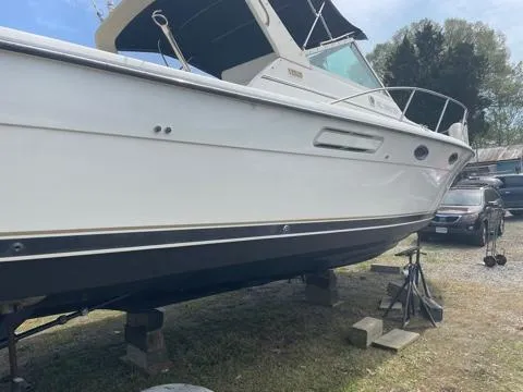 Slide: The Image of 1994 Tiara Yachts 3100 Open on dry dock, side view, white hull, outdoor setting. - 21