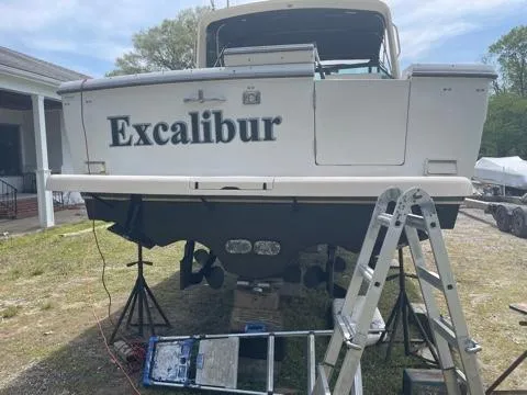 Slide: The Image of 1994 Tiara Yachts 3100 Open named "Excalibur" on land with maintenance equipment. - 22