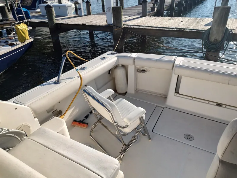 Slide: The Image of 1994 Tiara Yachts 3100 Open boat interior at dock, featuring seating and equipment. - 5