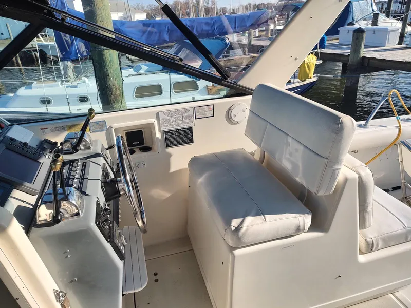 Slide: The Image of 1994 Tiara Yachts 3100 Open helm with white seating and control panel. - 9