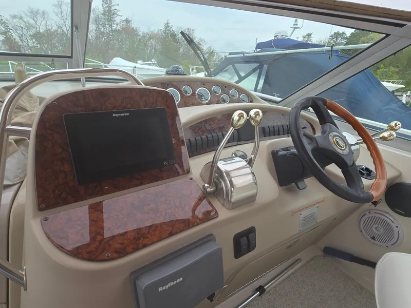 Slide: The Image of 2002 Sea Ray 340 Sundancer helm with steering wheel, controls, and navigation equipment. - 10