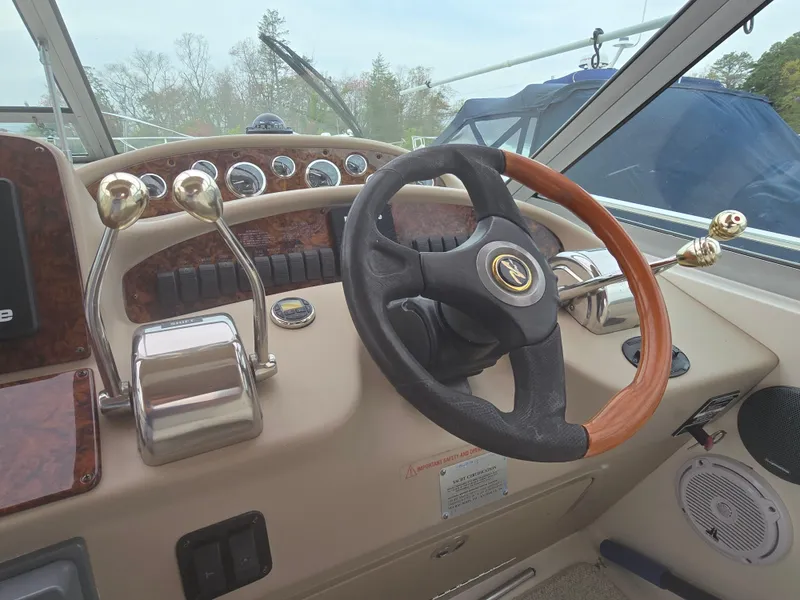 Slide: The Image of Steering wheel and controls of a 2002 Sea Ray 340 Sundancer boat cockpit. - 13