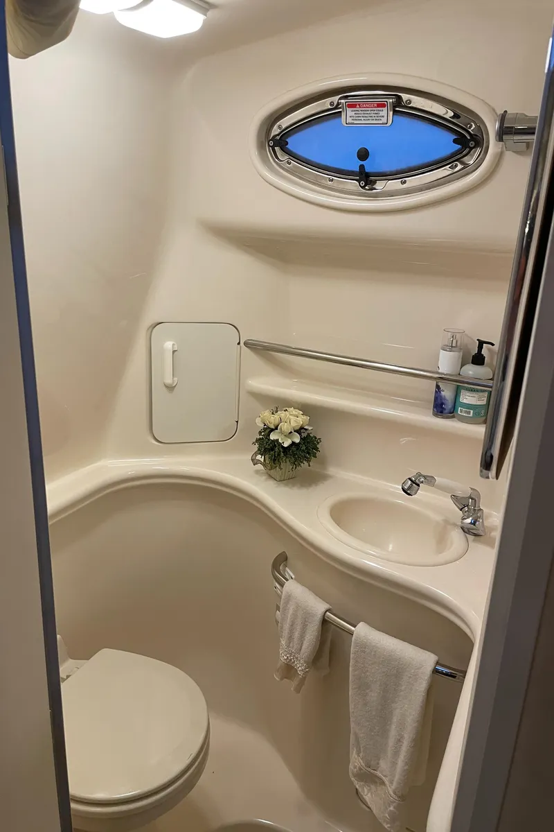 Slide: The Image of 2002 Sea Ray 340 Sundancer bathroom with sink, toilet, and porthole window. - 18
