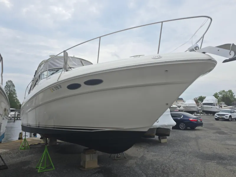 Slide: The Image of 2002 Sea Ray 340 Sundancer boat on dry dock, overcast sky background. - 2