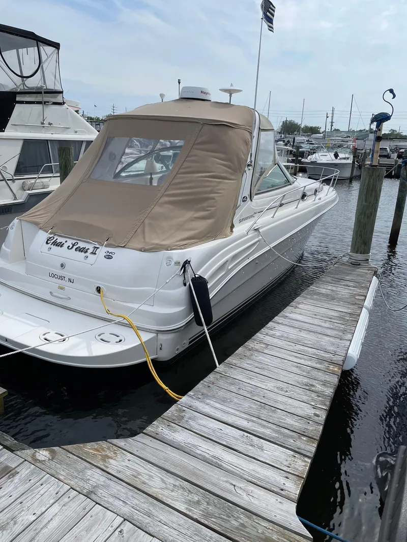 Slide: The Image of 2002 Sea Ray 340 Sundancer docked at marina, beige canopy, calm water. - 21