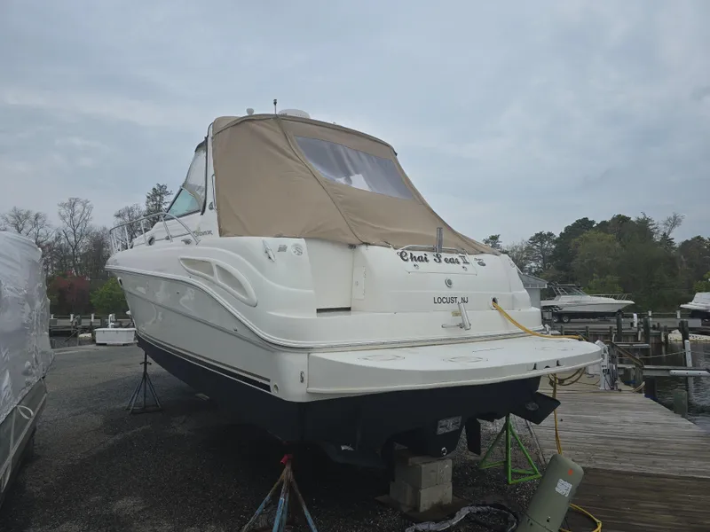 Slide: The Image of 2002 Sea Ray 340 Sundancer boat on dry dock with beige cover. - 4