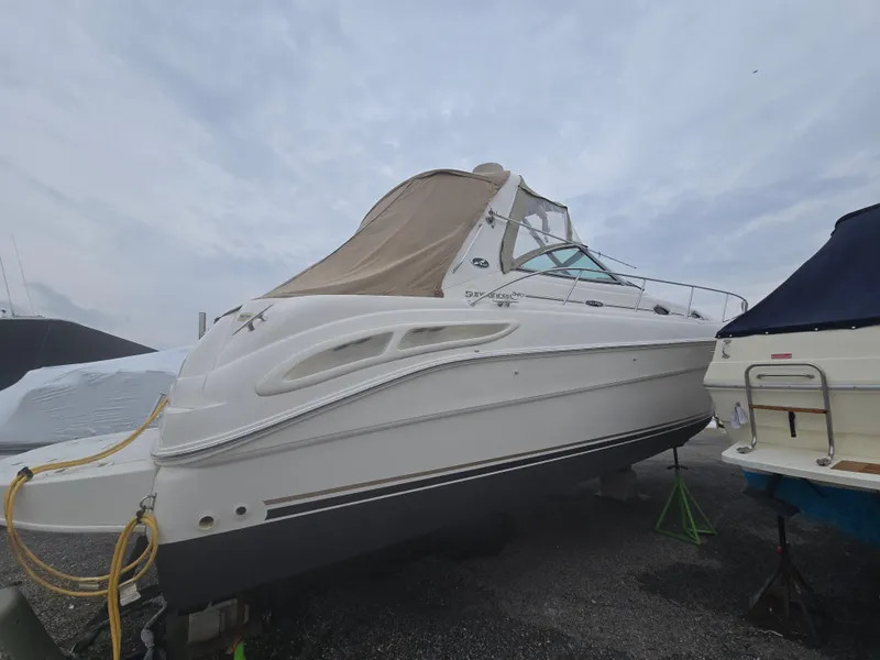 Slide: The Image of 2002 Sea Ray 340 Sundancer boat on dry dock, side view with overcast sky. - 5