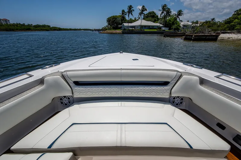 Slide: The Image of 2024 Tiara Yachts 38 LS boat interior with luxurious seating on a serene waterway. - 13