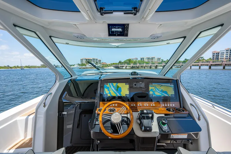 Slide: The Image of 2024 Tiara Yachts 38 LS helm with advanced navigation system and waterfront view. - 19
