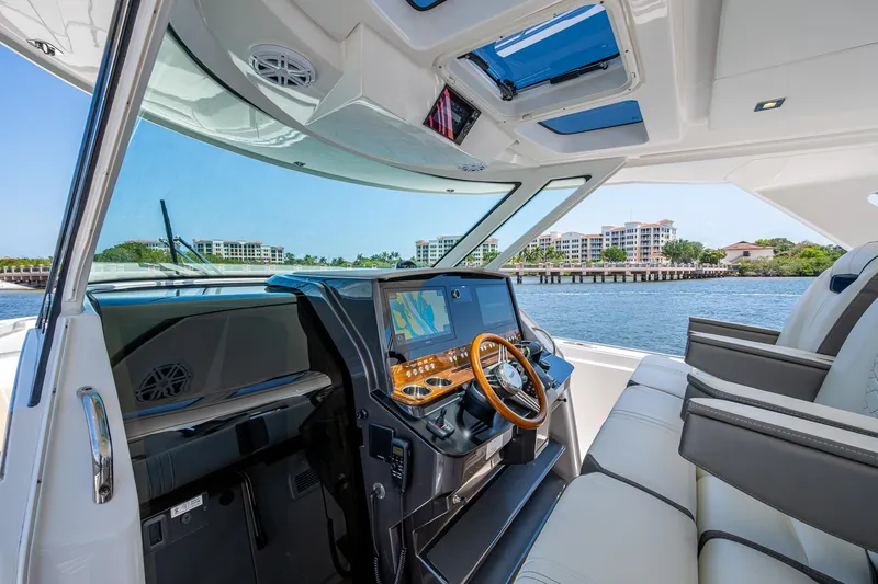 Slide: The Image of 2024 Tiara Yachts 38 LS helm with modern controls, luxurious seating, and waterfront view. - 20