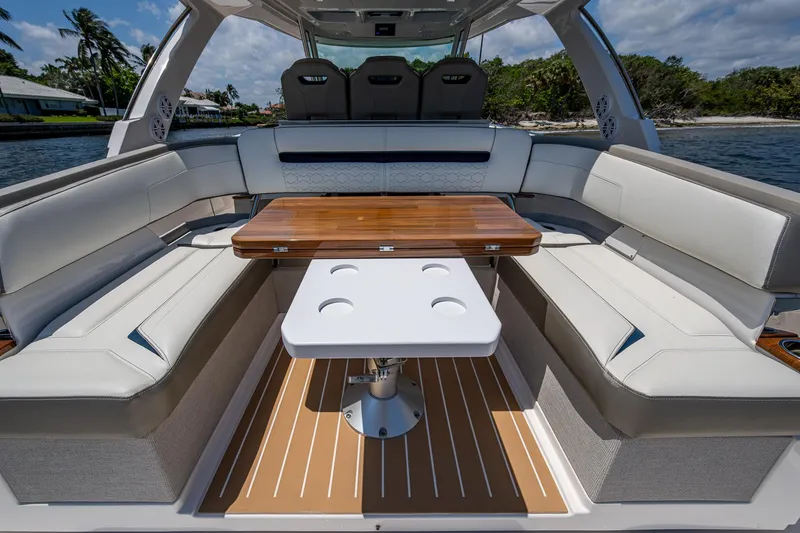 Slide: The Image of 2024 Tiara Yachts 38 LS interior with elegant seating and wooden table on a sunny day. - 27
