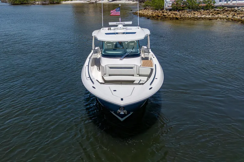 Slide: The Image of 2024 Tiara Yachts 38 LS boat on calm water, front view with American flag. - 3