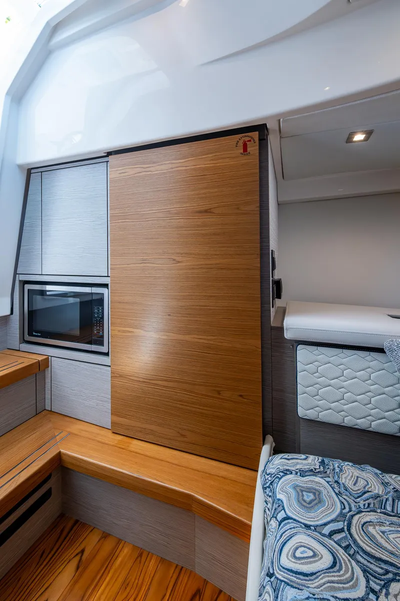 Slide: The Image of 2024 Tiara Yachts 38 LS interior with modern wood finishes and cozy seating. - 39