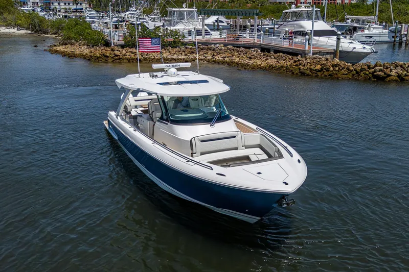 Slide: The Image of 2024 Tiara Yachts 38 LS cruising in a marina, showcasing sleek design and luxury features. - 4