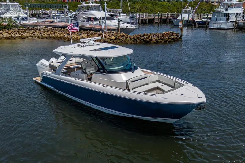 Slide: The Image of 2024 Tiara Yachts 38 LS luxury boat docked in a marina, featuring sleek design and spacious deck. - 5