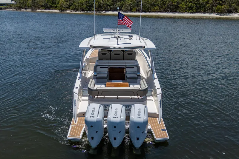 Slide: The Image of 2024 Tiara Yachts 38 LS with triple outboard engines on a calm waterway. - 9