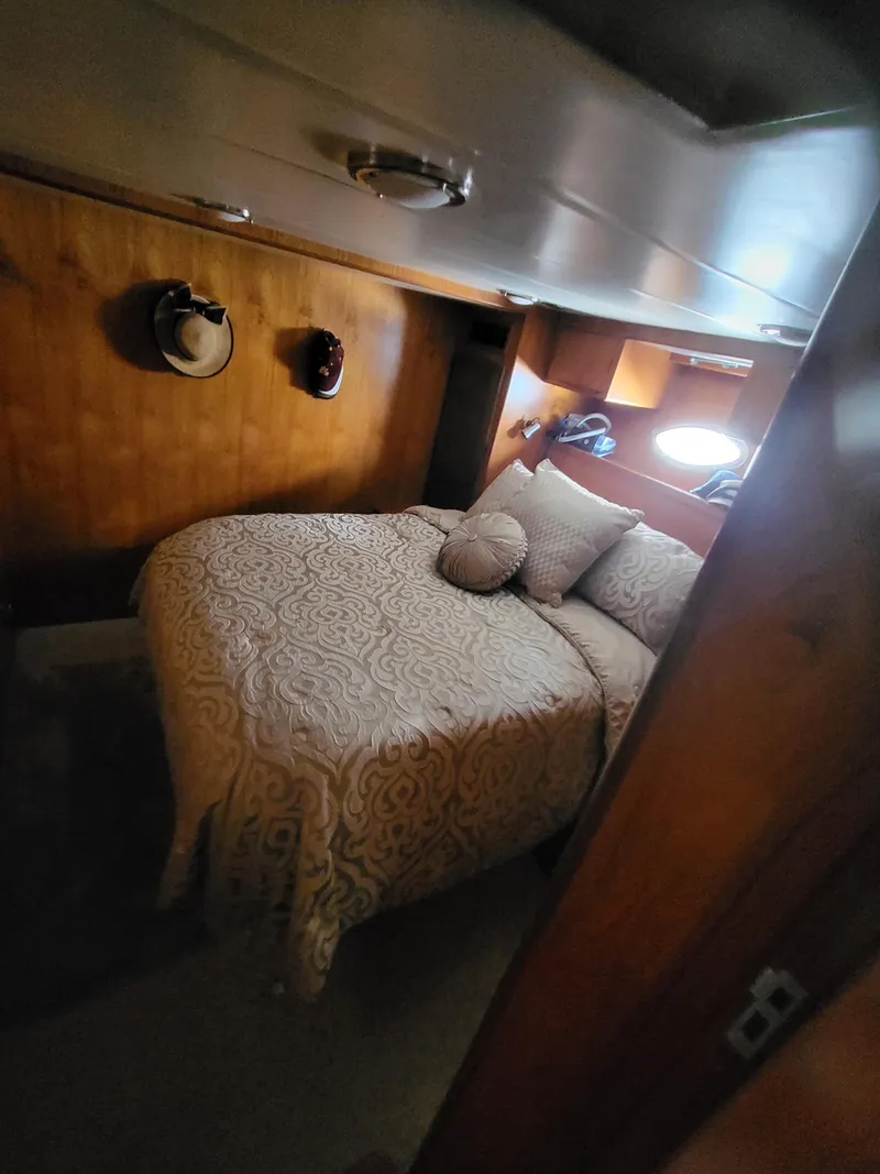 Slide: The Image of Cozy bedroom in 1997 McKinna 48' Pilot House with wood paneling and decorative bedding. - 15