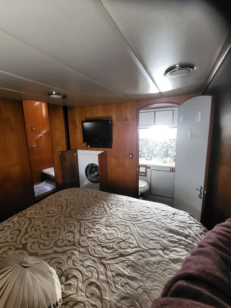 Slide: The Image of Interior of 1997 McKinna 48' Pilot House with bed, TV, and bathroom. - 16